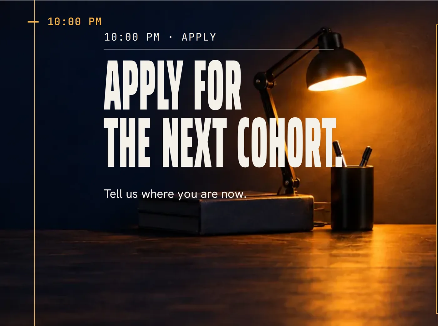 A night desk with an amber lamp, a pen pot and books beside the Apply for the next cohort headline.