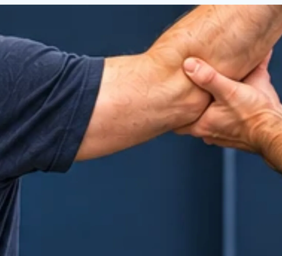 Hands gently testing a man's arm.