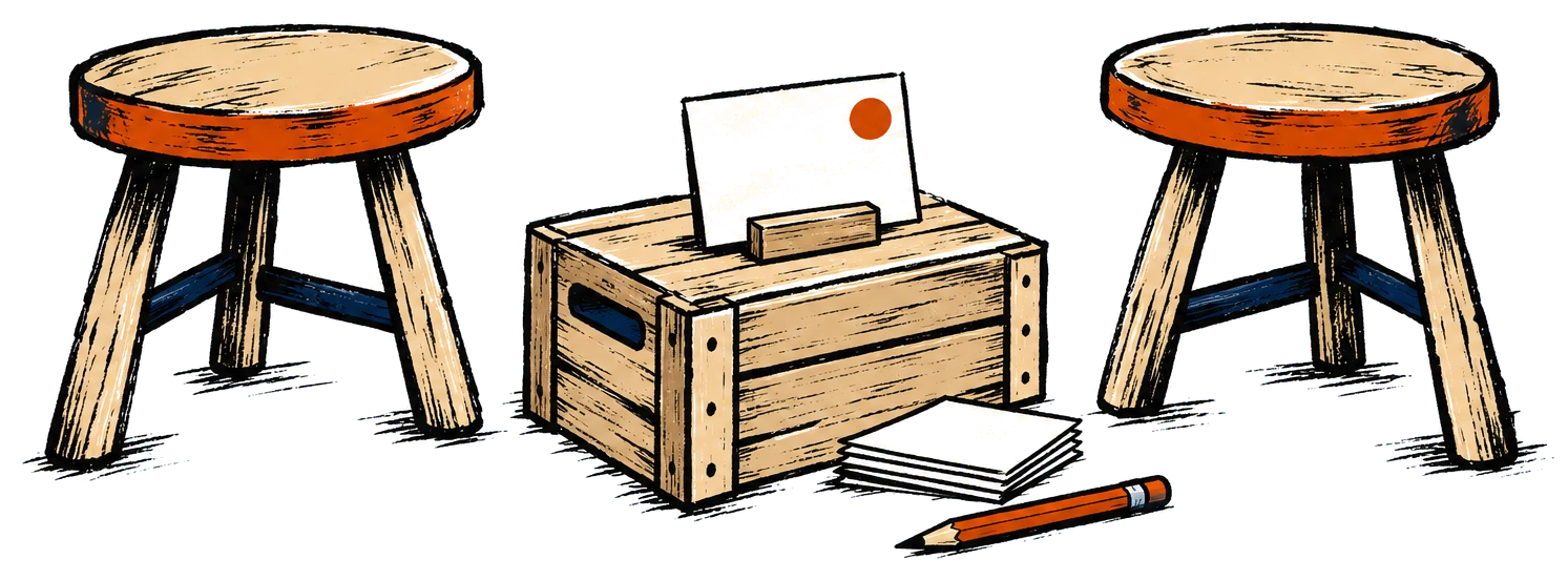 Two wooden stools facing each other across a crate that holds a blank card.